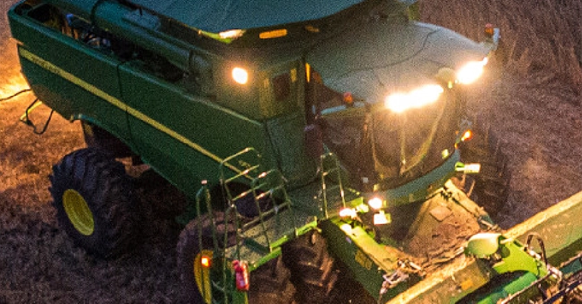 John Deere Combine in wheat field at night